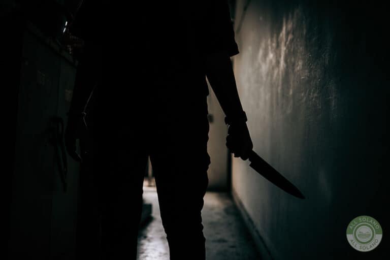 A dark silhouette of a murderer holding a large knife