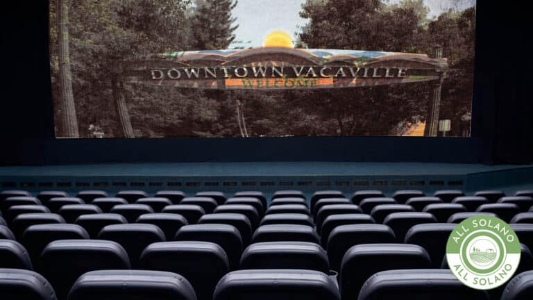 A large, empty movie theatre with a scene of downtown Vacaville on screen.