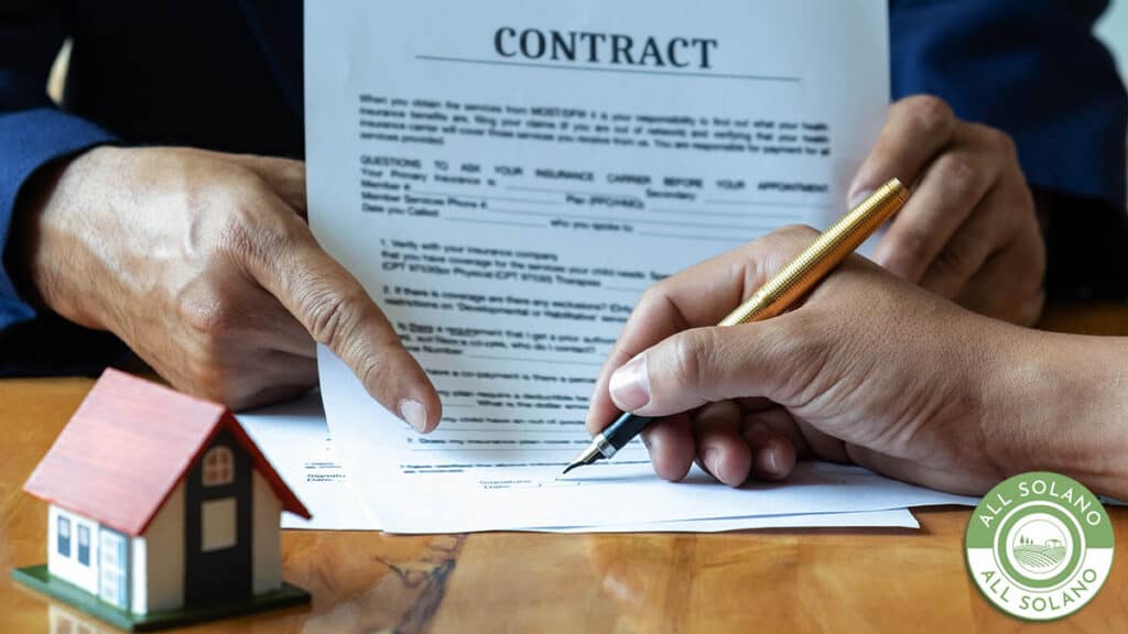 A home purchase contract is signed at a title company.