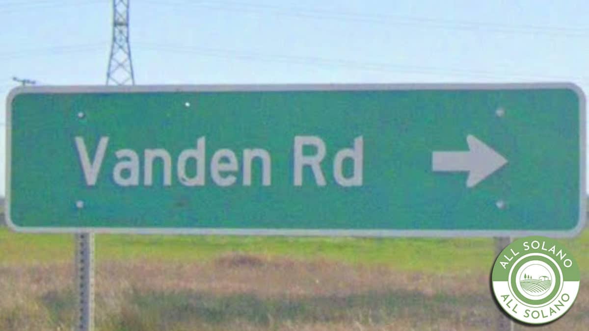 A green Vanden Road sign.